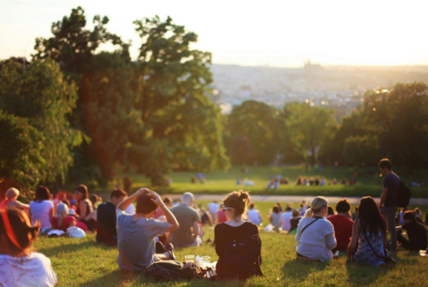 many people sitting in a grass field for an event