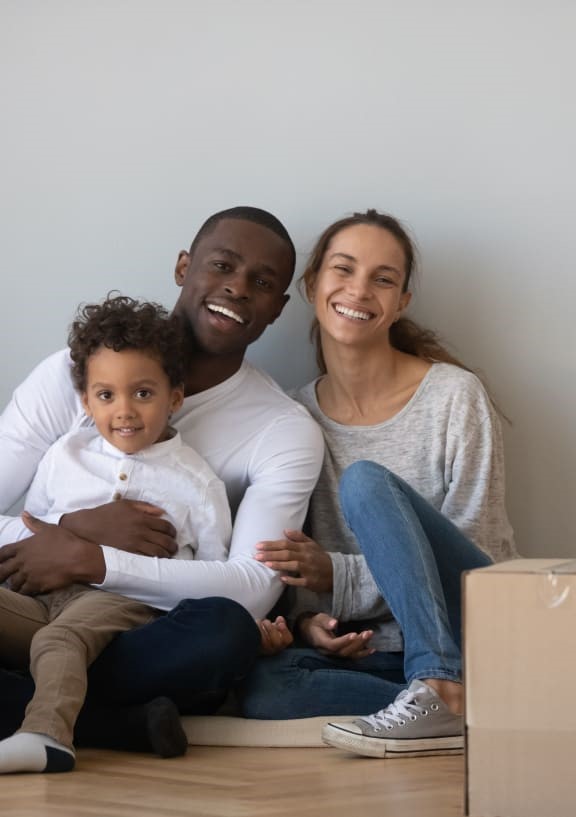 a couple sitting with their child and posing for a picture