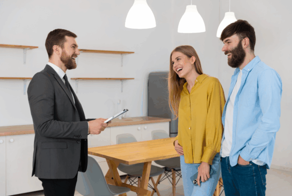 Couple discussing concerns with a real estate agent, highlighting the importance of resident feedback in affordable housing and property management services.